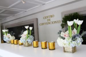 a row of vases filled with flowers on a table at Mayaguez Resort & Casino in Mayaguez