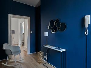 a room with a blue wall with a table and a chair at Les Appartements Saint-Martin in Colmar