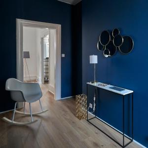 a blue room with a chair and a blue wall at Les Appartements Saint-Martin in Colmar