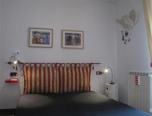 1 dormitorio con 1 cama y 2 cuadros en la pared en la casa di anita en Rio Marina