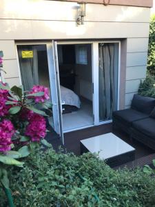a screened in porch with a couch and flowers at Secret Garden by Arder in Gdynia