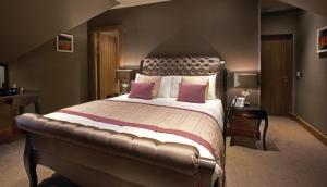 1 dormitorio grande con 1 cama grande con almohadas rosas en The Parkville Hotel en Hamilton