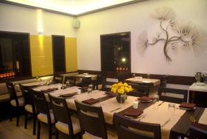 a dining room with tables and chairs with flowers on the wall at Sea Palace Hotel - near Gateway of India in Mumbai