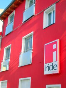 a red building with windows and a sign on it at Iride Guest House in Oristano