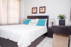 a bedroom with a large white bed with blue pillows at Seabrook 210 in Margate