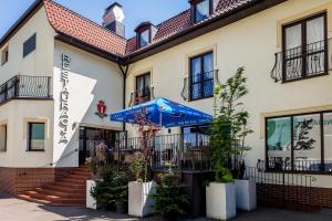 un hotel con sombrilla frente a un edificio en Hotel Walewscy en Gdańsk-Rębiechowo