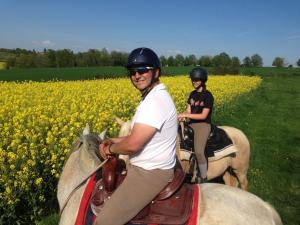 un homme et une femme à cheval dans un champ dans l'établissement LA NOALHA INSOLIT', à Lanouaille