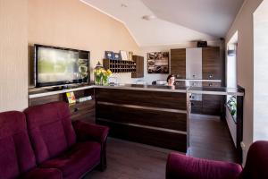 a woman sitting at a bar in a hotel room at Hotel Walewscy in Gdańsk-Rębiechowo