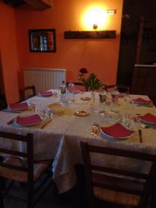 パッシニャーノ・スル・トラジメーノにあるAgriturismo Villa Rancioの白いテーブルクロスとメガネのテーブル