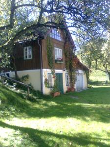 una casa con techo de paja en un patio verde en Weinzettl en Türnitz