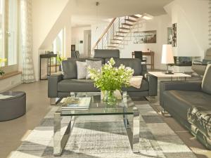 un soggiorno con un divano e un tavolo con fiori di "FIRST" Sellin Penthouse "Meerblick & SPA" a Ostseebad Sellin