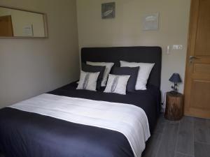 une chambre avec un grand lit avec des oreillers blancs et noirs dans l'établissement La Villa Provençale, à Lorgues 53 autres photos