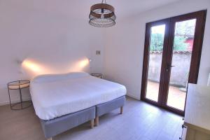 a white bedroom with a bed and a large window at La Briciola in Sirmione