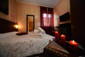 a bedroom with a large bed with two red candles at Hotel Okinawa in Rimini