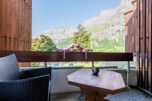 a table and chairs on a balcony with a view of mountains at Hotel Quellenhof Leukerbad in Leukerbad +59 photos