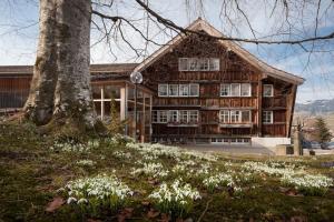 a house with a tree and flowers in front of it at Ferienhotel Idyll Gais in Gais +43 photos