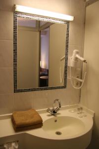 a bathroom with a sink and a mirror at Rhein-Hotel in Andernach