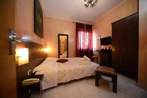 a bedroom with a bed and a table and a chair at Hotel Okinawa in Rimini