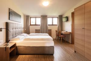 Habitación de hotel con cama y escritorio en Landgasthof Bad Turmbach en Appiano sulla Strada del Vino