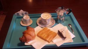 uma bandeja azul com bolos e uma chávena de café em Cascina Angela em Gavi