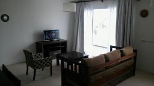 a living room with a couch and a tv and a window at Sol Patagonia in Río Gallegos
