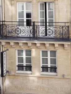 a balcony on the side of a building with windows at Hotel Louvre Saint-Honoré in Paris