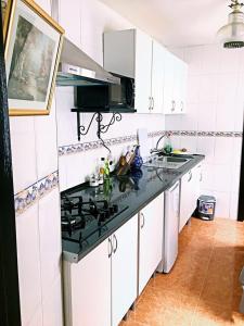 a kitchen with white cabinets and a black counter top at Casa Ronda 1808 in Ronda