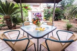 een tafel en stoelen met een fruitschaal erop bij Mandarinoarancio in Alezio