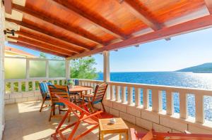 a deck with a table and chairs and the water at Apartments Ranko in Zavalatica