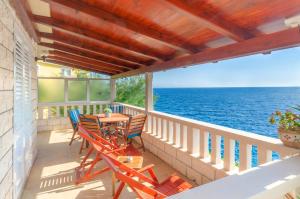 a balcony with chairs and a table and the ocean at Apartments Ranko in Zavalatica