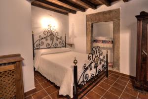 a bedroom with a black and white bed and a mirror at Casa Tia Emilia in Villar de Plasencia