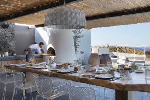 una sala da pranzo con tavolo e sedie di Erosantorini Estate a Firà