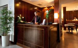 a man is standing at a reception desk at Toledo Imperial in Toledo