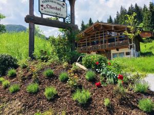 a sign and flowers in front of a building at Feriendorf Oberhof in Flachau
