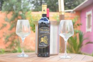 a bottle of wine sitting next to two wine glasses at Sa Mariposa in Muravera +56 photos