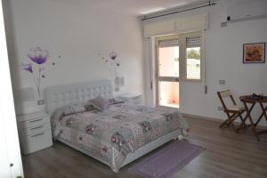 a bedroom with a bed and a table and a window at Sa Mariposa in Muravera