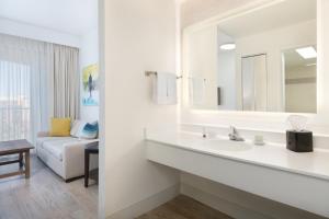 圣徒皮特海滩Sirata Beach Resort St Pete Beach的一间带水槽和镜子的浴室以及一张沙发