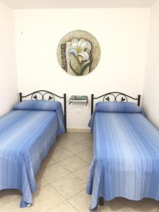 Habitación con 2 camas y un plato en la pared. en Casa Vacanza Zia Dani, en Castro di Lecce