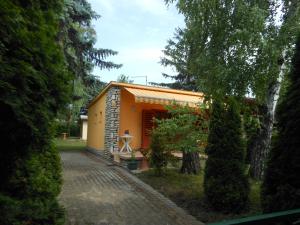ein kleines gelbes Haus mit einer steinernen Einfahrt in der Unterkunft Cozy Family Cottage at the Lake in Siófok