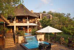 a resort with a swimming pool and a house at Crocodile Kruger Safari Lodge in Marloth Park
