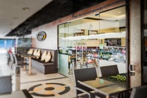 un restaurante con mesas y sillas y una ventana en The Ambiance Hotel, en Pattaya central