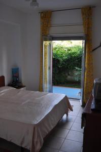 een slaapkamer met een bed en een glazen schuifdeur bij Arancio residence in Taormina