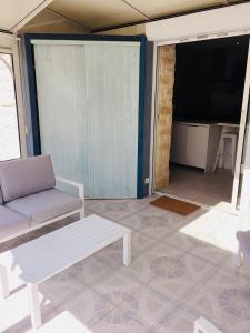 a living room with a couch and a tv at Cosy villa La Garancière - Plein coeur de la Cotinière in La Cotinière