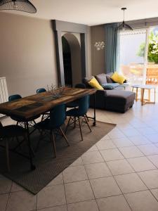 a living room with a wooden table and a couch at Cosy villa La Garancière - Plein coeur de la Cotinière in La Cotinière