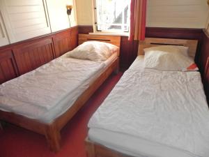 2 Einzelbetten in einem Zimmer mit Fenster in der Unterkunft Ostseepark Waterfront Captains Haus 17 in Heringsdorf