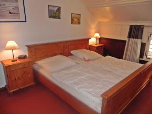 ヘリングスドルフにあるOstseepark Waterfront Captains Haus 17のベッドルーム1室(大型木製ベッド1台、ランプ2つ付)