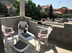 un gruppo di sedie e un tavolo sul balcone di Apartments AS a Budua