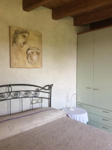 una camera da letto con un letto e un dipinto sul muro di B&B Locus Amoenus a Vobarno