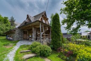 a small log cabin in a garden at Domek Szałas pod Dębem in Ząb