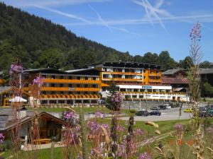 un gran edificio con una montaña en el fondo en Azureva La Clusaz les Confins en La Clusaz